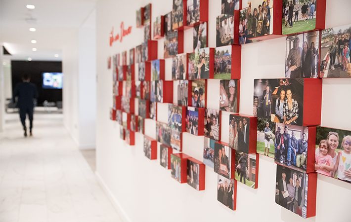 Wall with photos of JLL employees and their families
