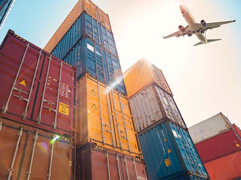 Airplane flying above cargo container