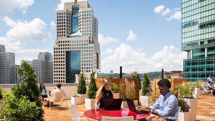 Two office workers collaborate on a rooftop terrasse of a Corporate building